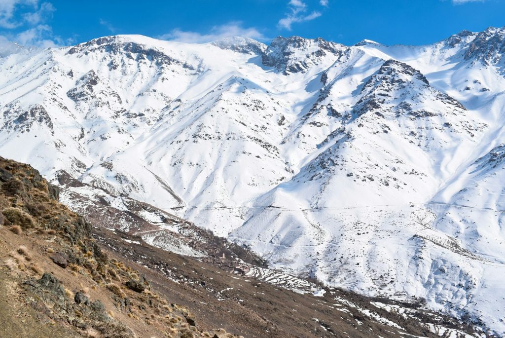 A man riding a mountain bike down a snow covered slope